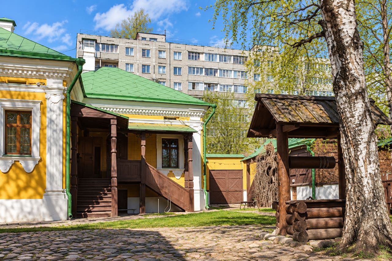 Жёлтый музейный дом и деревянный колодец во дворе